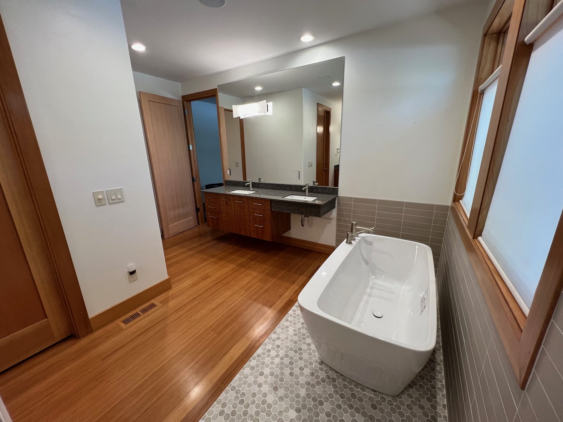 Bathroom remodel with freestanding tub and warm wood accents
