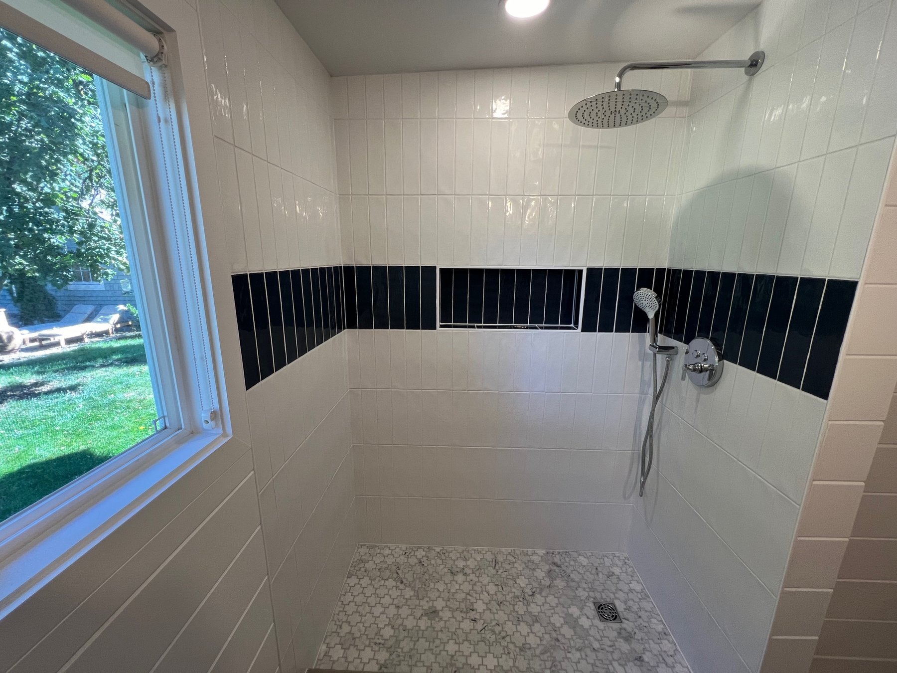 Walk-in tile shower with a decorative accent stripe