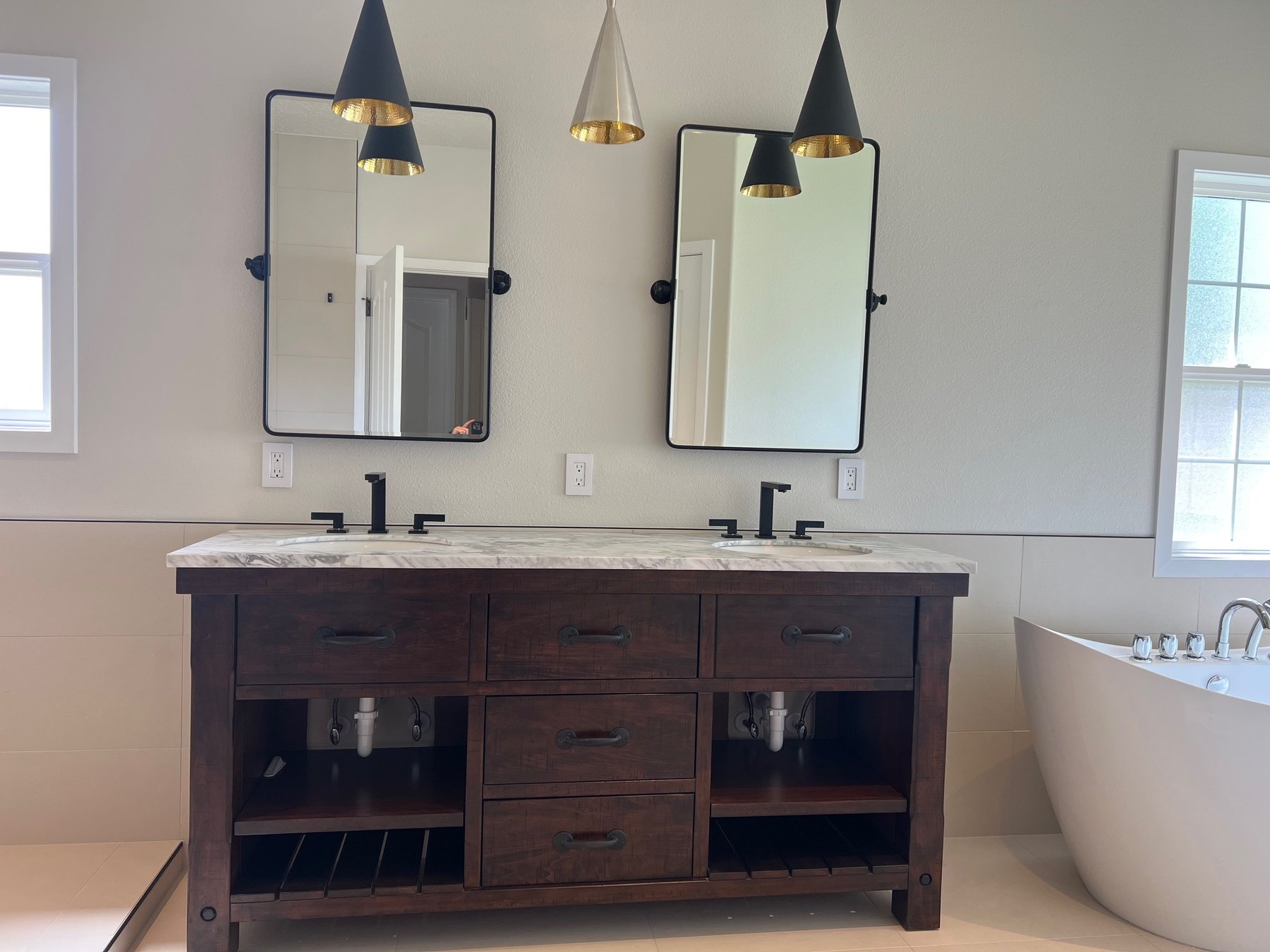 Double vanity bathroom lit by hanging pendant lights