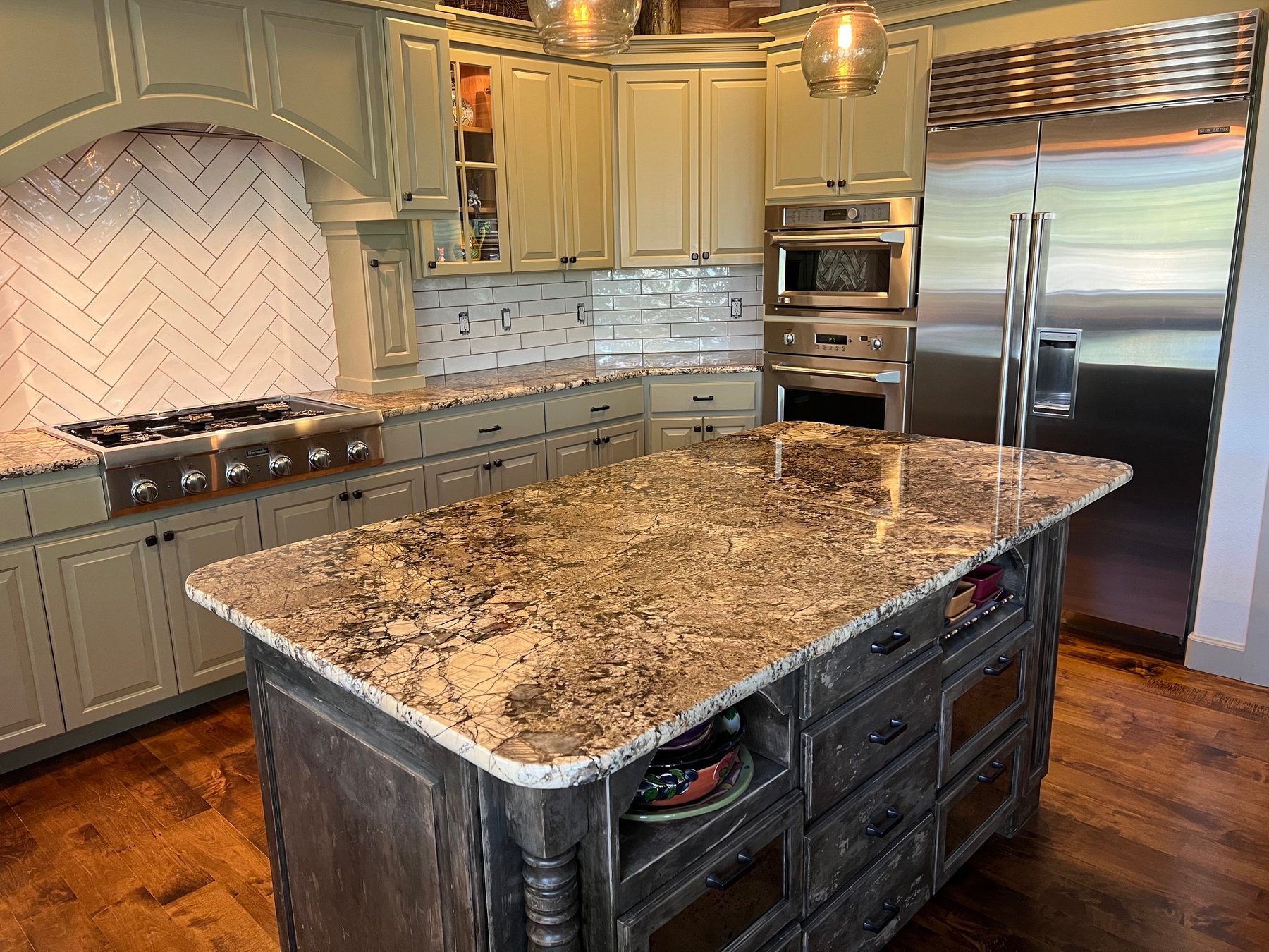 Kitchen with sage green island and painted cabinets