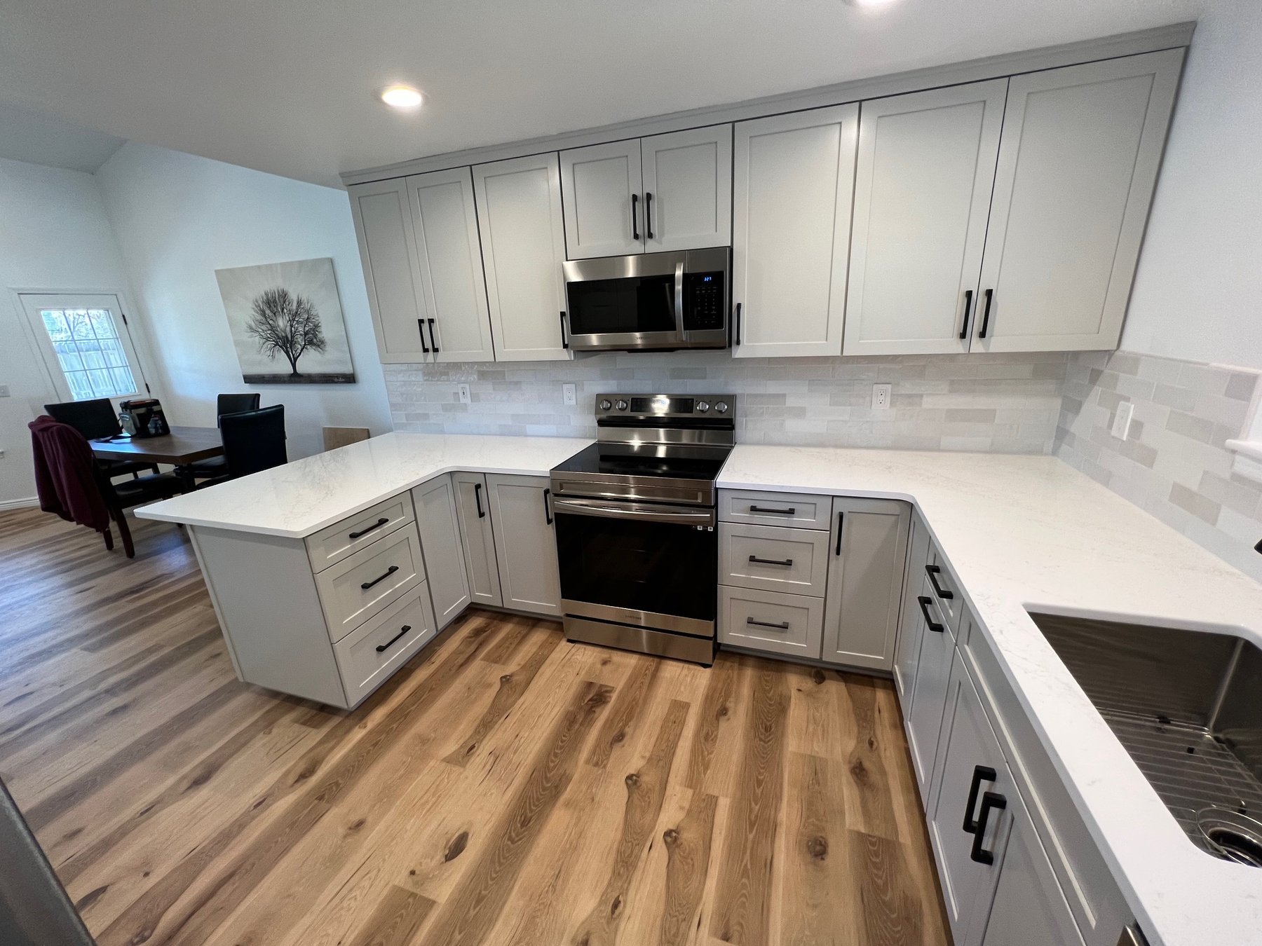 Open-concept white shaker kitchen with dining area