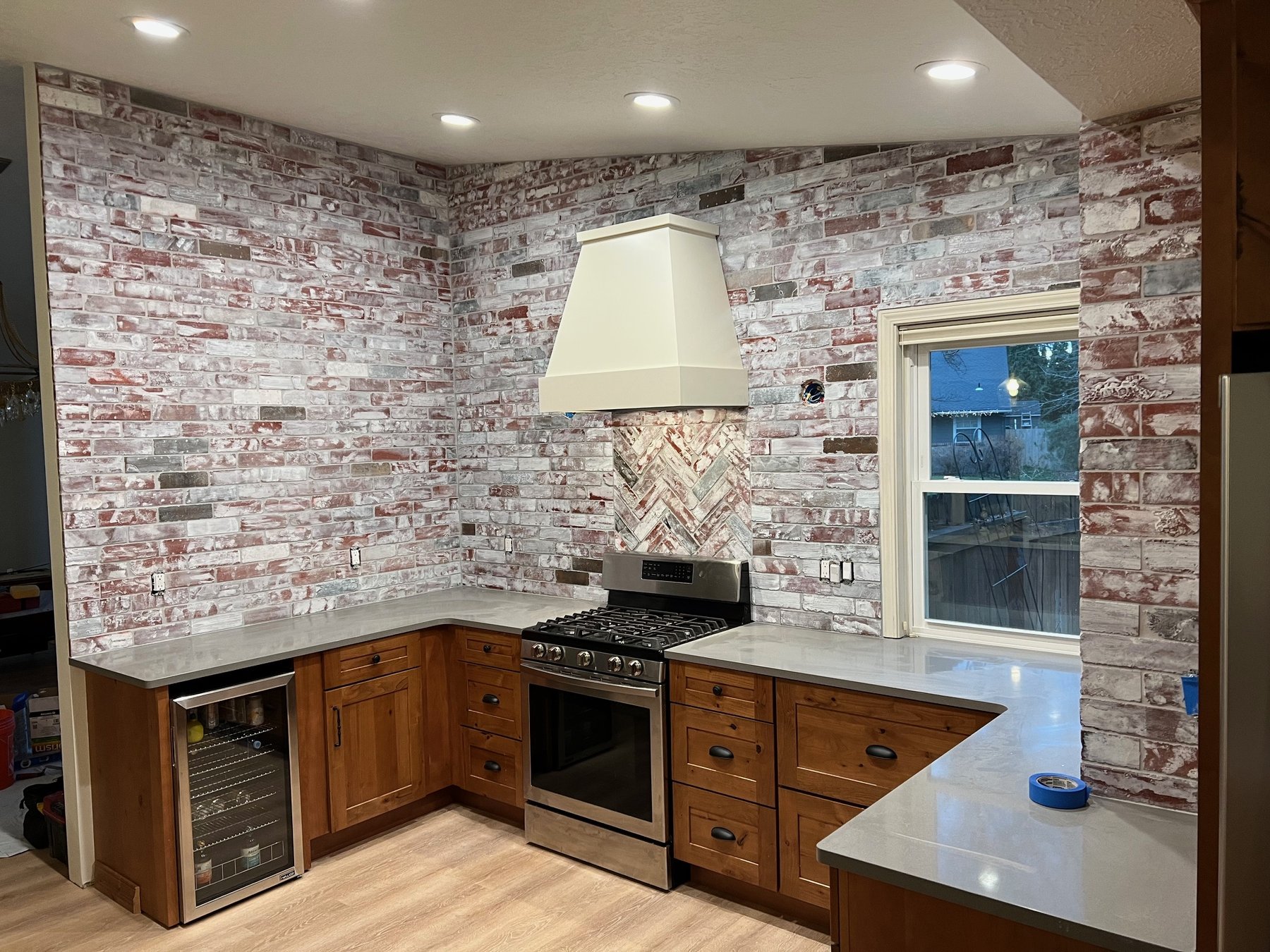 Kitchen bar area with exposed brick and wood shelving